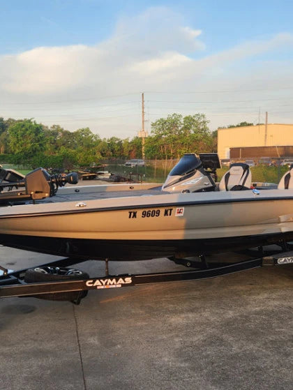 Picture of a Caymas bass boat in a parking lot. 